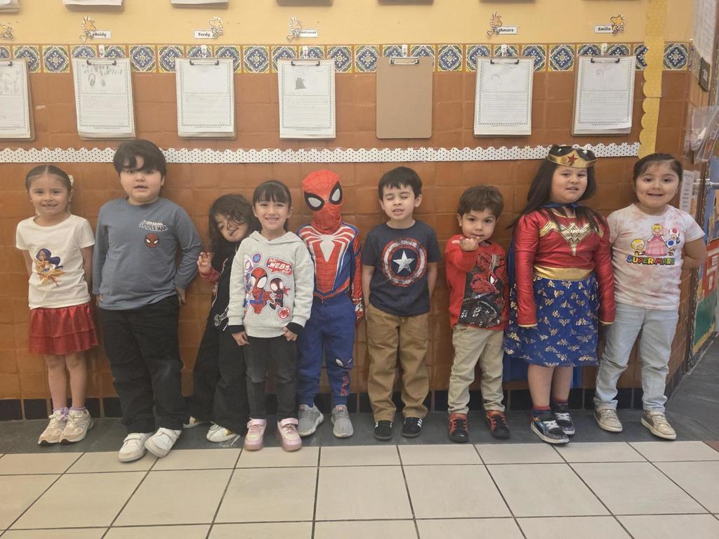 Nine students wearing super hero outfits.