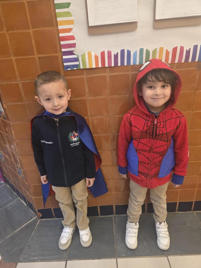 two students lined up wearing a cape and a spiderman hoodie