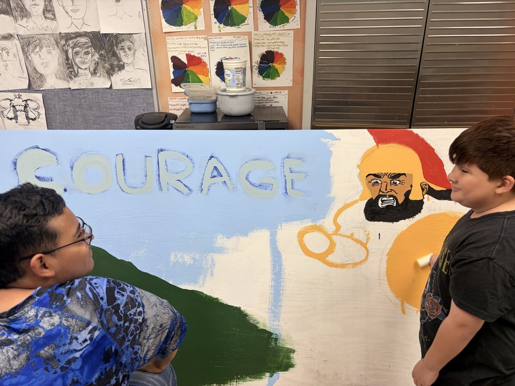 Two kids examine a mural on a wall that says "Courage" and depicts a man with a beard.