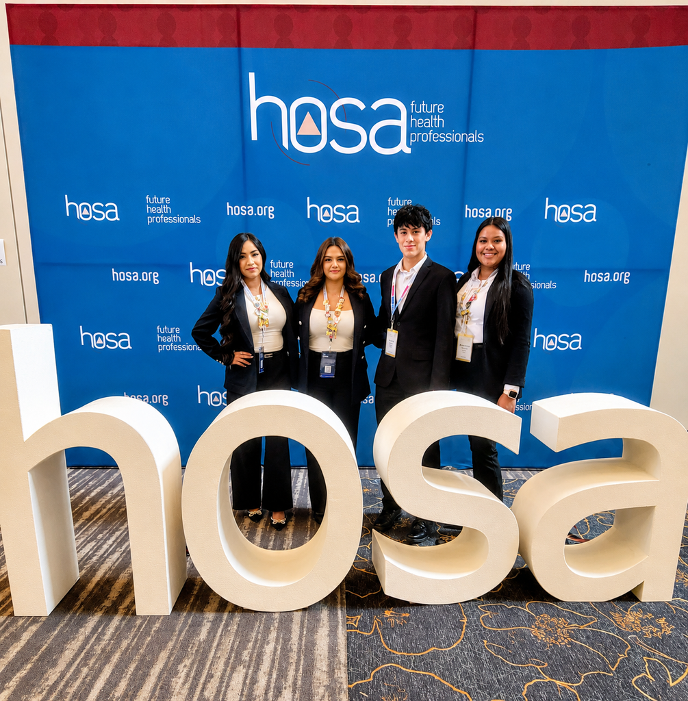 Four individuals, wearing suits, stand behind a "HOSA" sign. A blue banner is behind them.