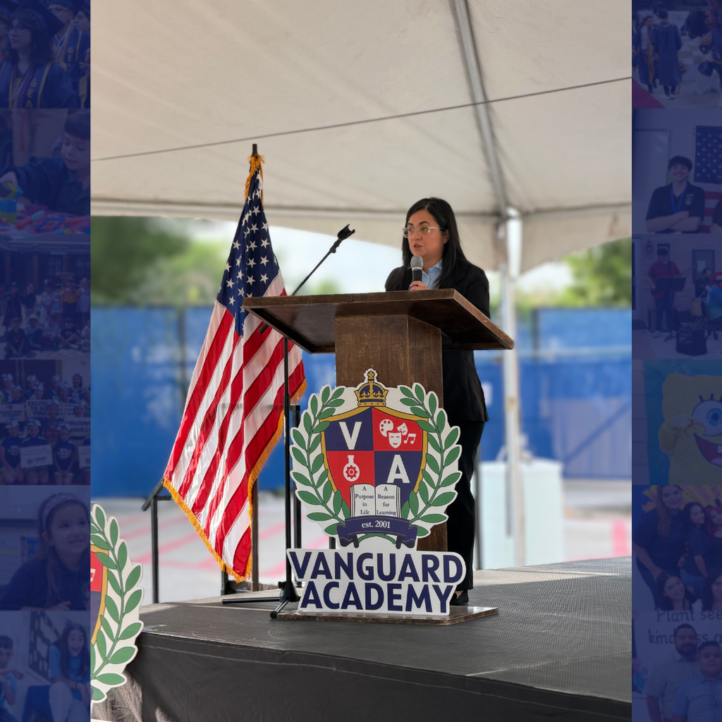 A woman speaks at a podium with a Vanguard Academy sign and an American flag behind her.