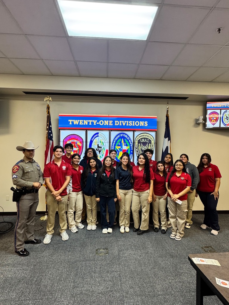 Group of people in red uniforms standing in front of a banner that says "TWENTY-ONE DIVISIONS" with American flag.