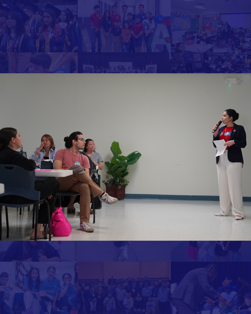 A woman speaks into a microphone while holding a paper. People are seated behind her. A potted plant is beside them.