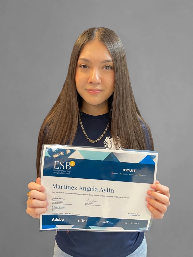 A young woman with long hair holding a certificate. The certificate reads "Martinez, Angela Aylin" and "ESB".