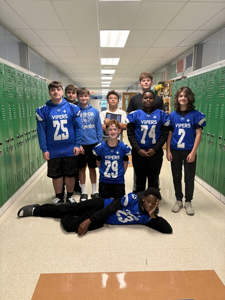 football players in uniform in school hallway