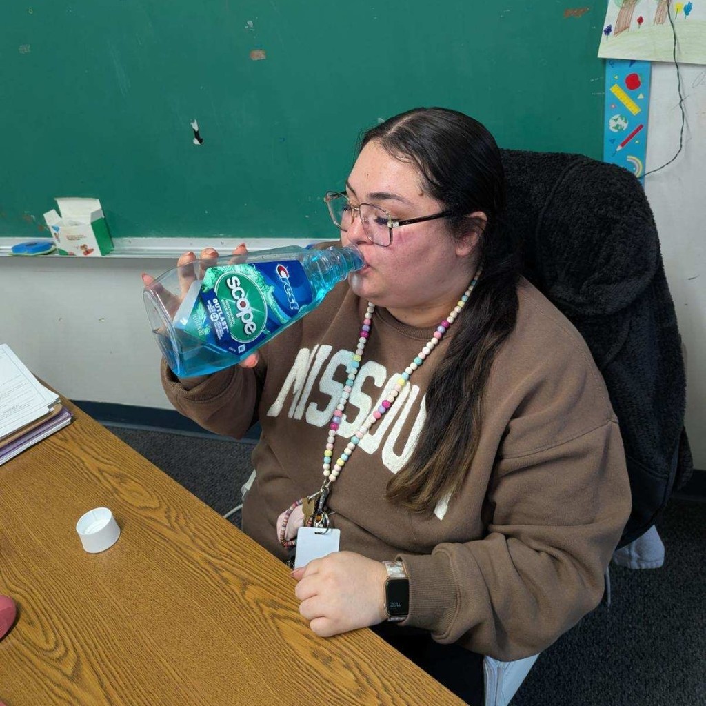 Ms. Avilla drinking Blue Powerade from a mouthwash bottle.