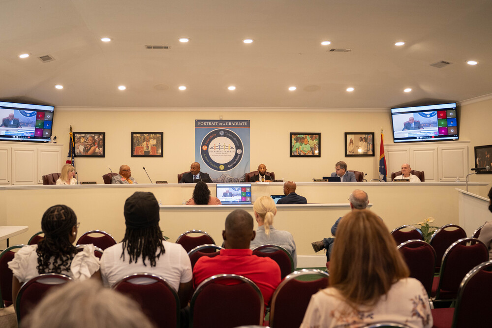  An overview of the school board meeting, showing board members, district leadership, and audience members gathered for the evening's recognitions and updates.