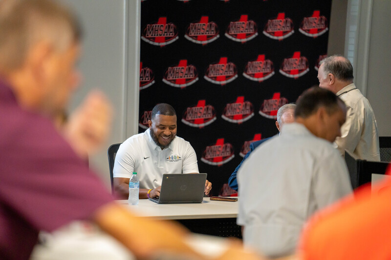 Coach Lewis smiling before he presents to athletic leaders across the state.