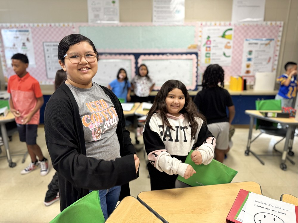 two students smiling at camera in classroom