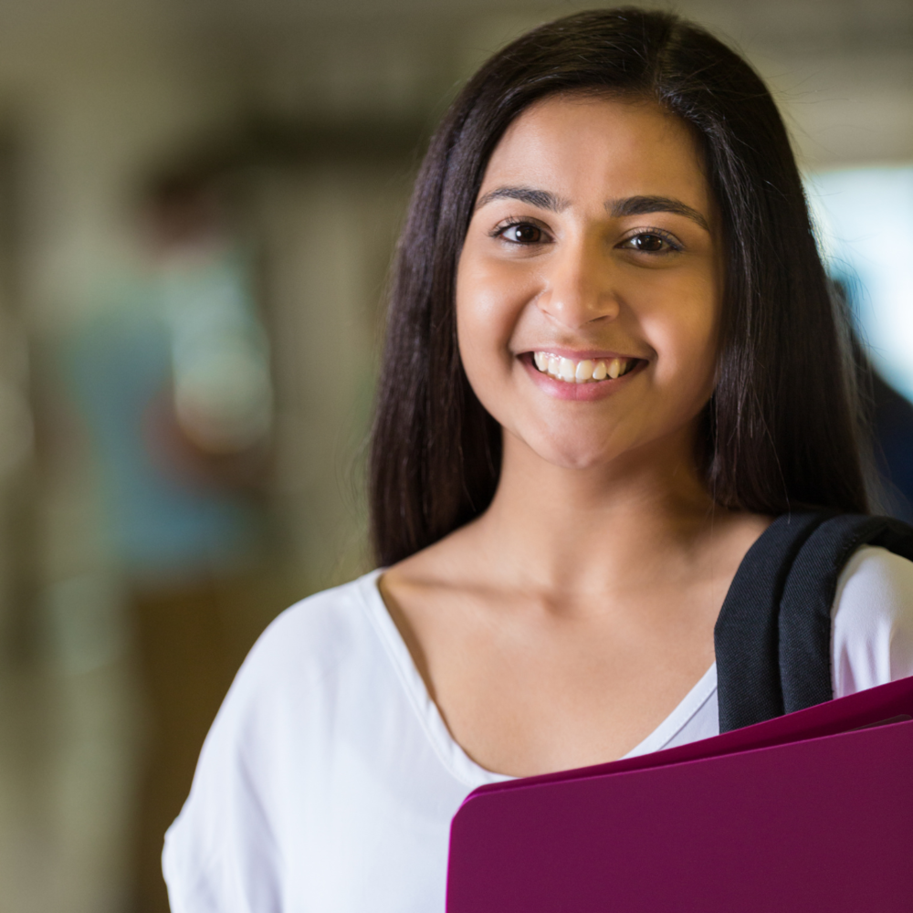 Girl holding binder carying backpack