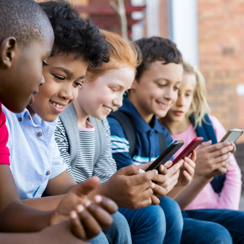 Smiling Students looking down on  their cell phone devices