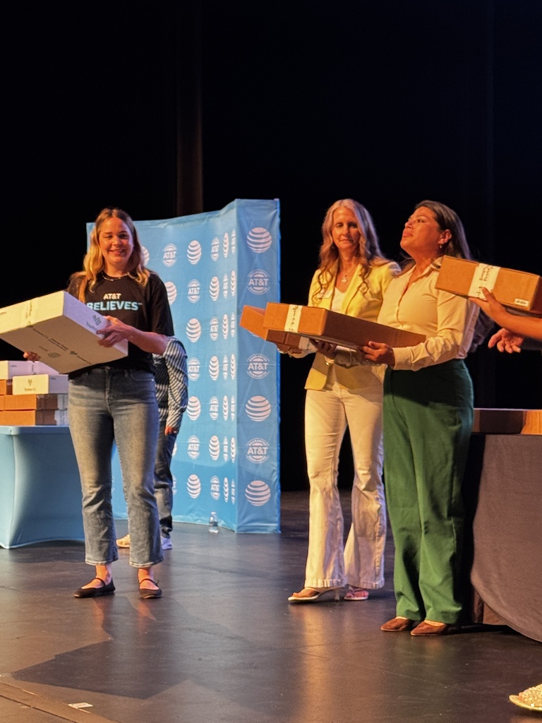 Foundation representatives handing out laptops to students during the July 9th distribution event. 