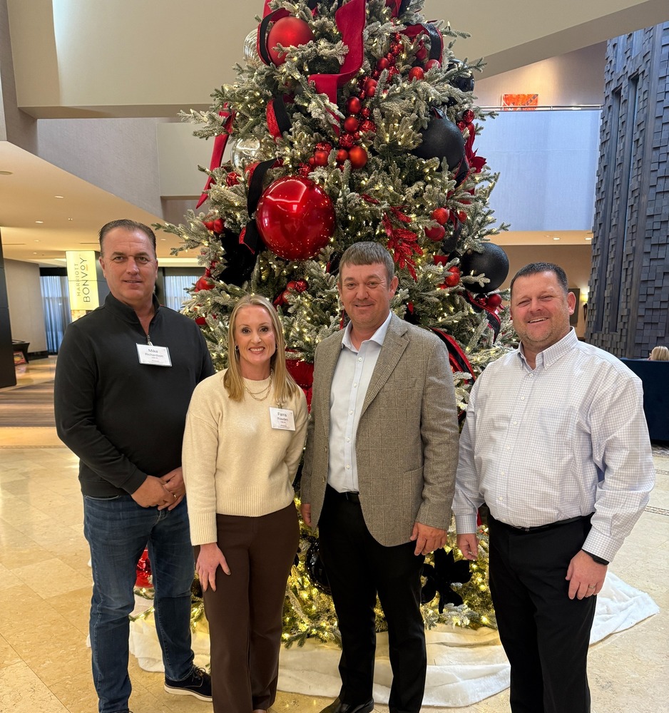 Board Members Mike Richardson, Farra Rowden, and Charlie Wray with Superintendent Kyle McCarn in front of a Christmas tree at Arkansas School Boards Association annual conference