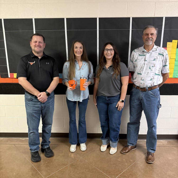 3 adults standing in front of a wall
