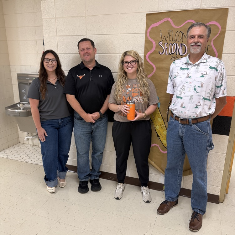 3 adults standing in front of a wall