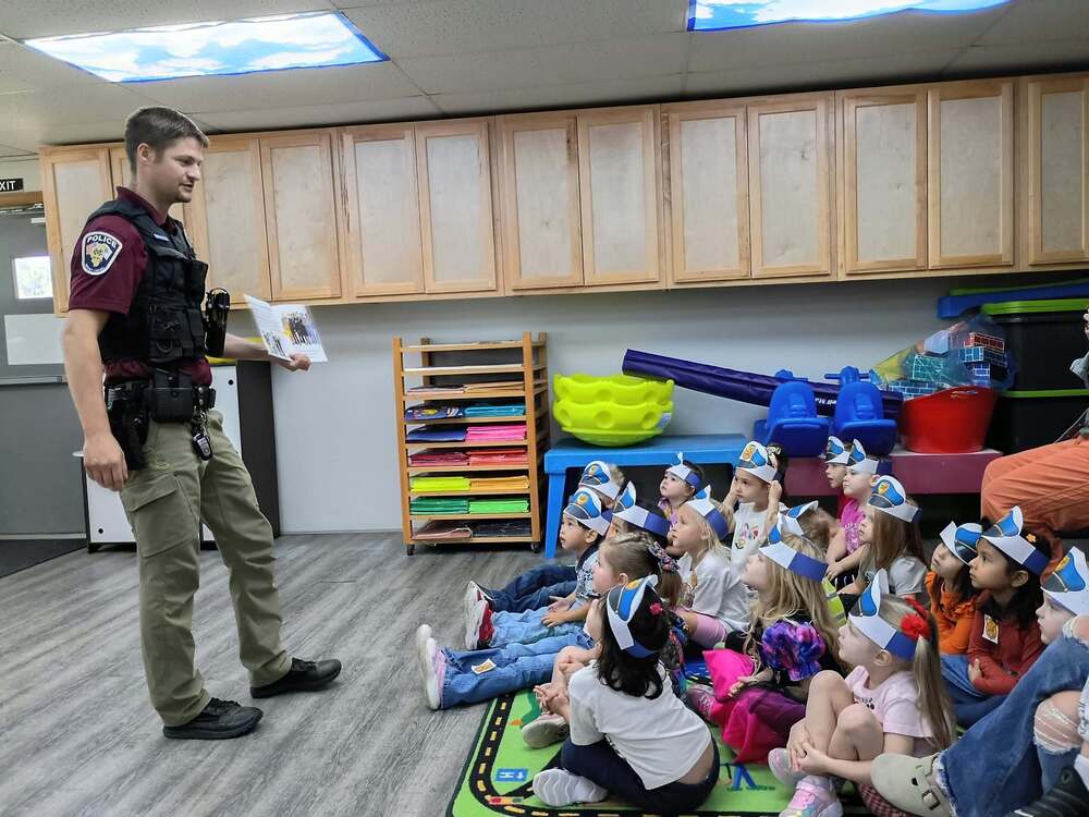 Officer Emmons reads to preschoolers.