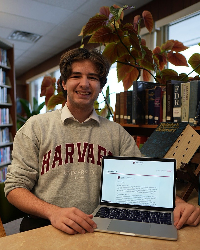 McBroom poses next to his acceptance letter from Harvard