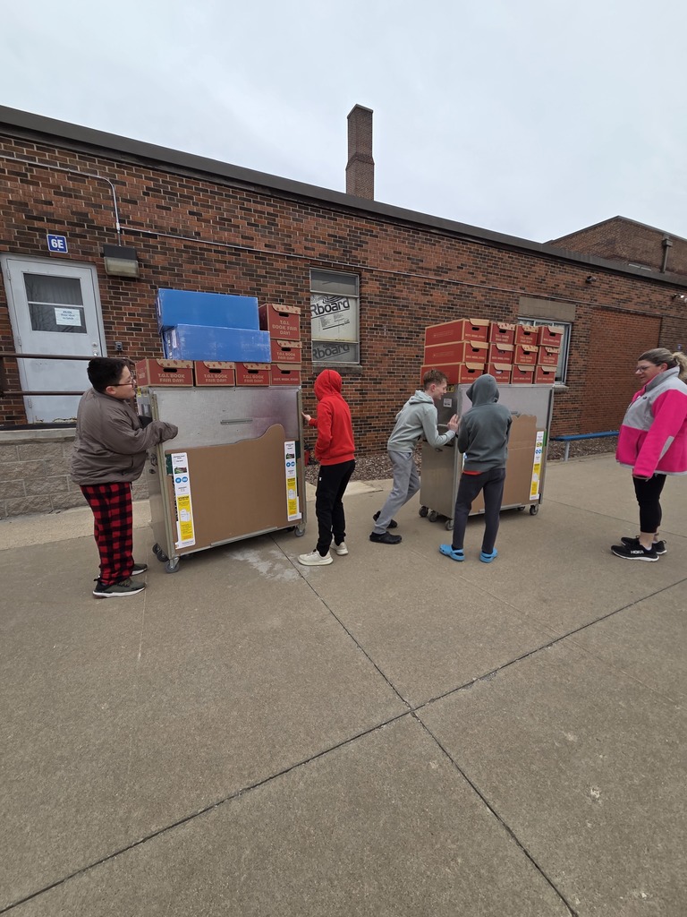 6th graders help get all the book cases inside