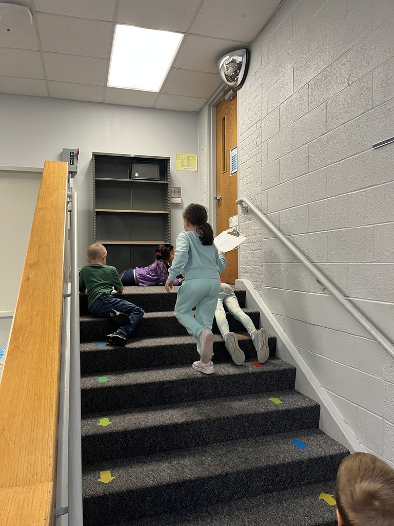 Students on stairs with clipboards.