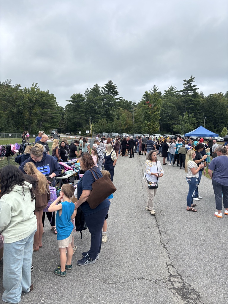 A picture of families at the Wakefield BBQ, standing outside talking and getting backpacks