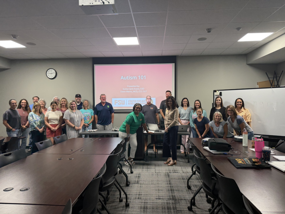 Administrators smiling for picture of an Autism Training by FSU