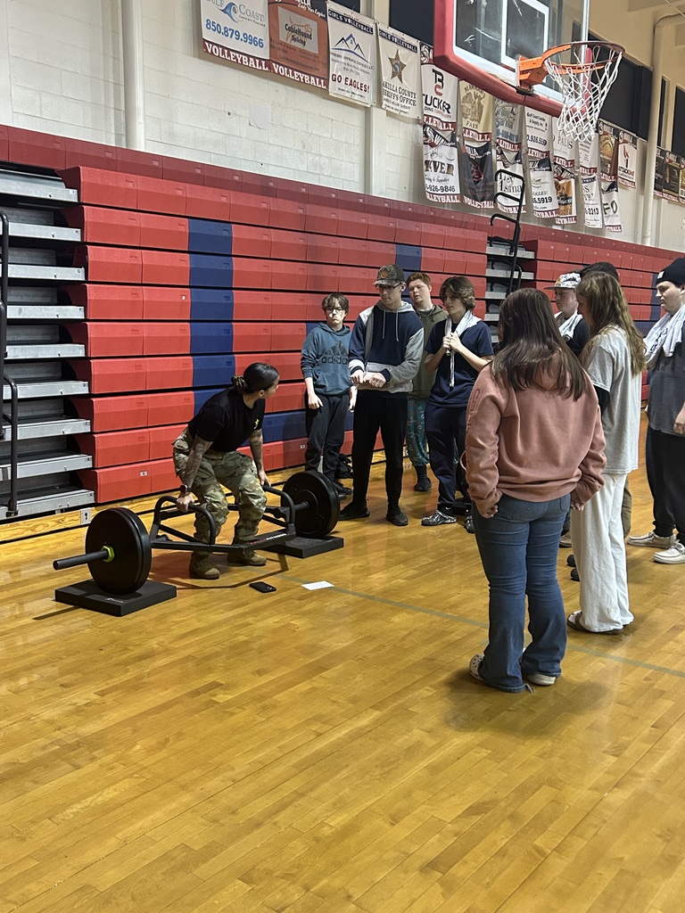 Army lady showing students how to weight lift 