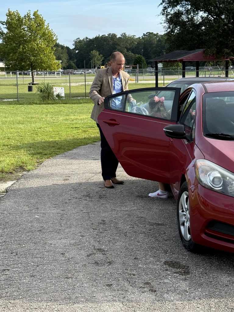 Wakulla County Schools Superintendent Rick Myhre, Florida Department of Education Senior Vice Chancellor Paul Burns, and Executive Director of the Office of Safe Schools Tim Hay greet students and help open car doors during morning arrival on the first day of school.