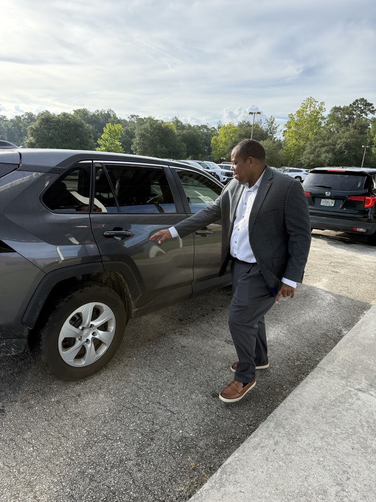 Wakulla County Schools Superintendent Rick Myhre, Florida Department of Education Senior Vice Chancellor Paul Burns, and Executive Director of the Office of Safe Schools Tim Hay greet students and help open car doors during morning arrival on the first day of school.
