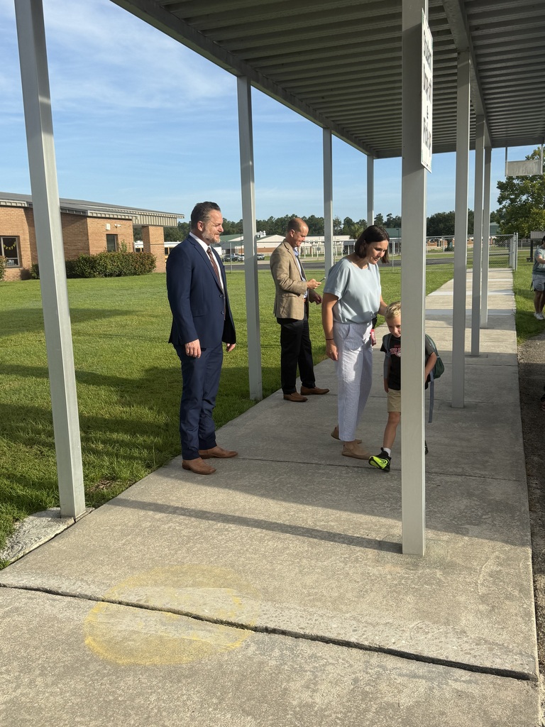 Wakulla County Schools Superintendent Rick Myhre, Florida Department of Education Senior Vice Chancellor Paul Burns, and Executive Director of the Office of Safe Schools Tim Hay greet students and help open car doors during morning arrival on the first day of school.