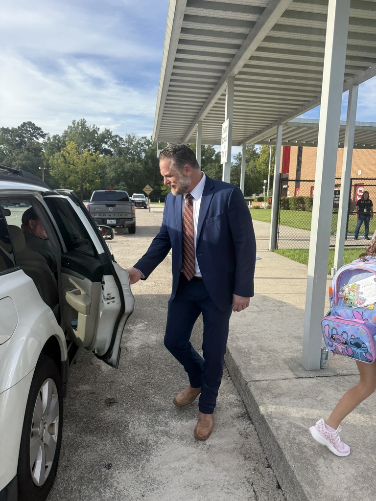 Wakulla County Schools Superintendent Rick Myhre, Florida Department of Education Senior Vice Chancellor Paul Burns, and Executive Director of the Office of Safe Schools Tim Hay greet students and help open car doors during morning arrival on the first day of school.