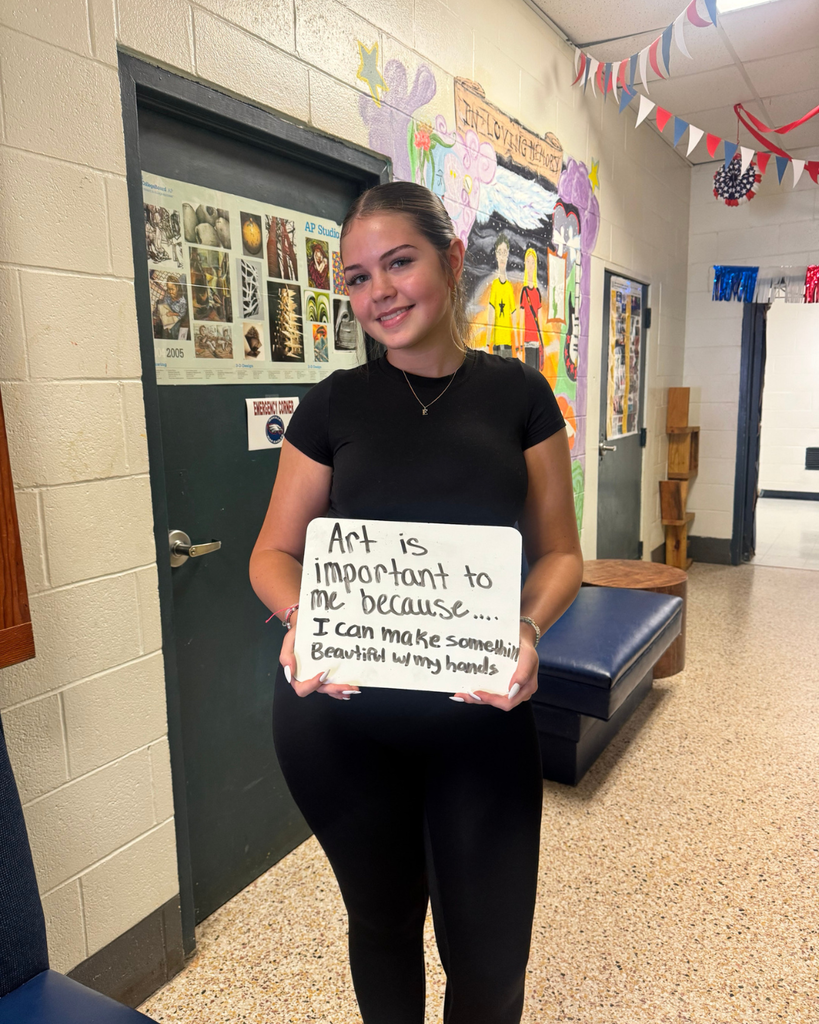 The image pictures a student with a sign that says,"Art is important to me because...I can make something beautiful with my hands "