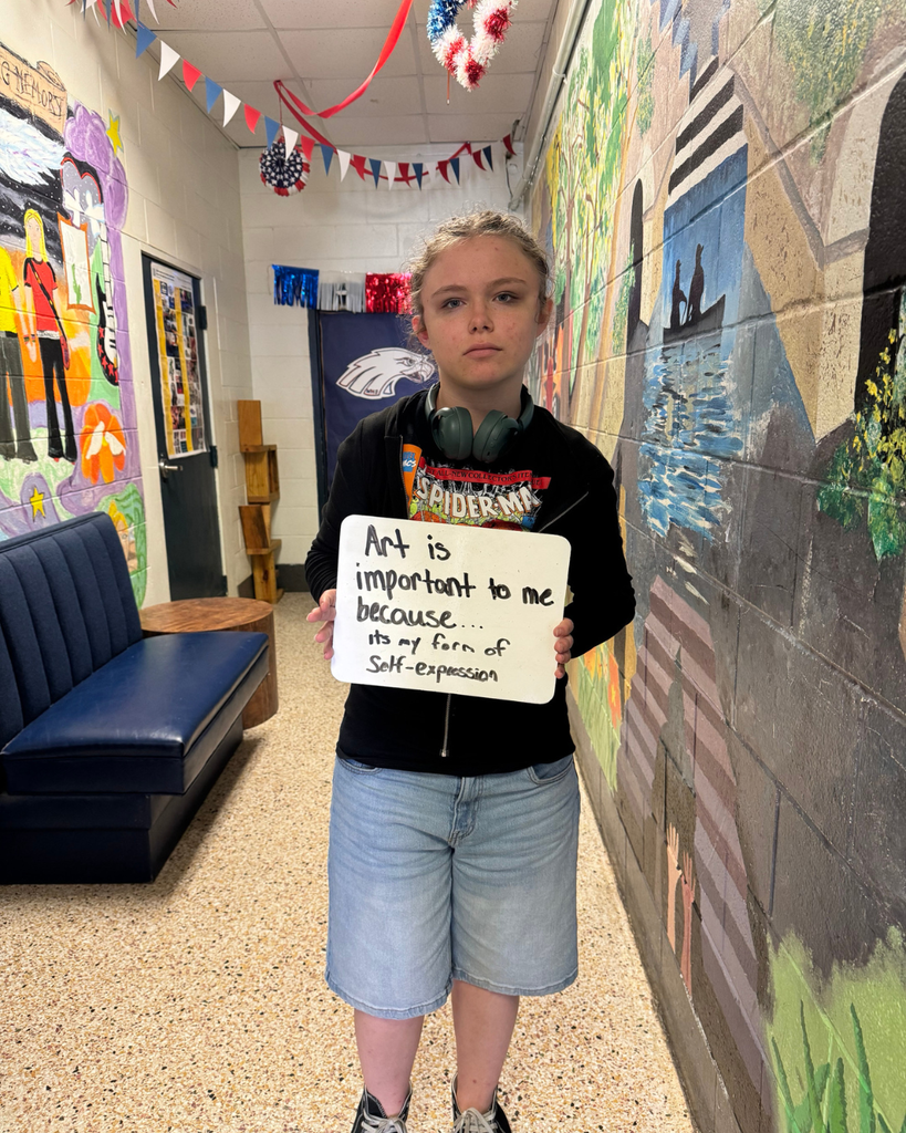 The image pictures a student with a sign that says,"Art is important to me because...it's my form of self-expression"