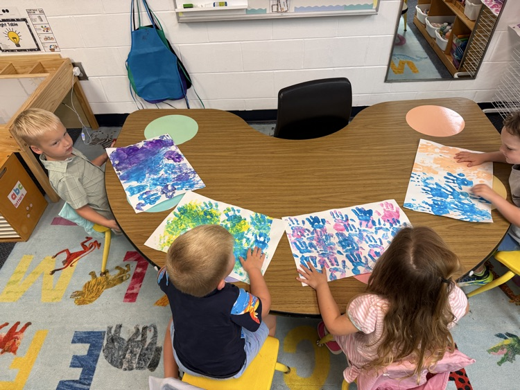 PreK students experiment with hands on materials to create an “All About Me” project about themselves 