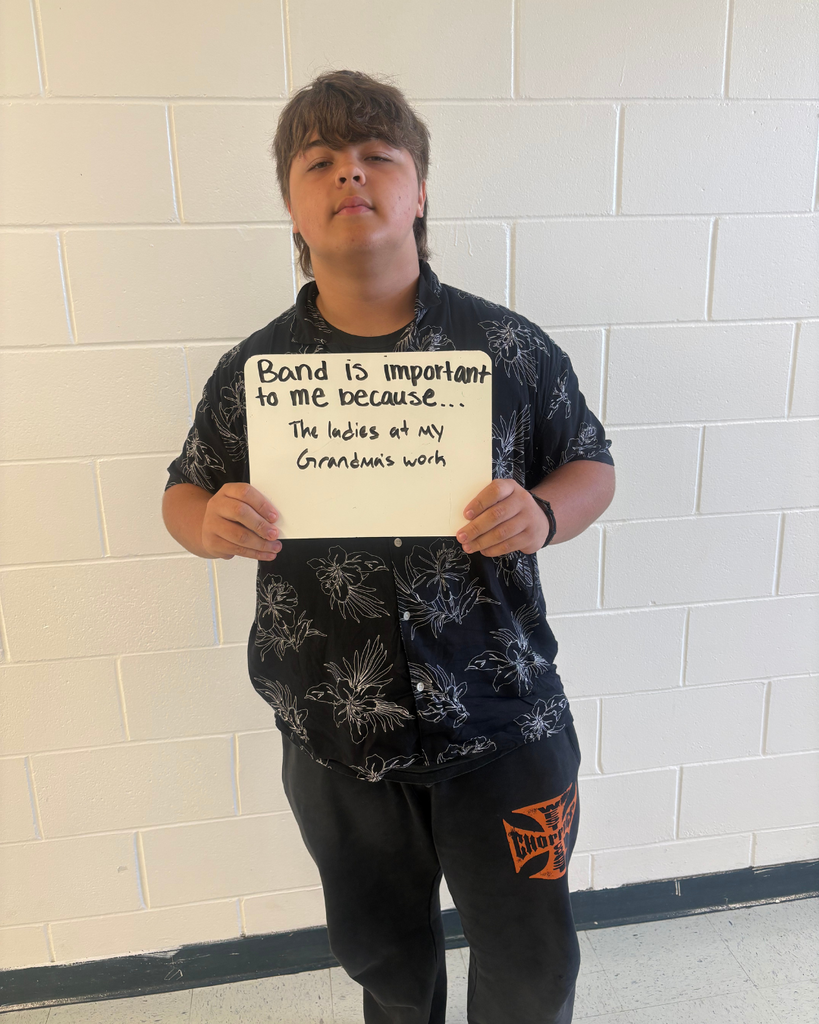 A student holding a sign saying,"Band is important to me because...the ladies at my grandmas work"