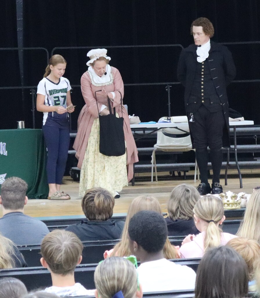 A student participates on stage with Founding Voices who were visiting RMS