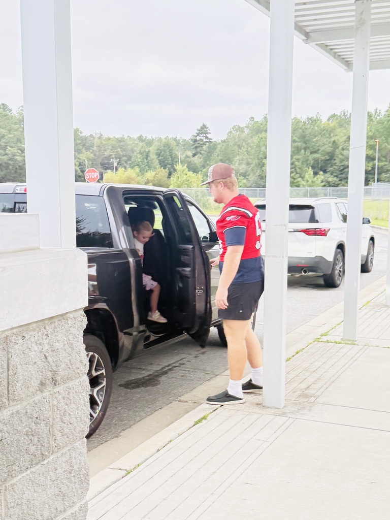 Football Player opening the door for an RES student
