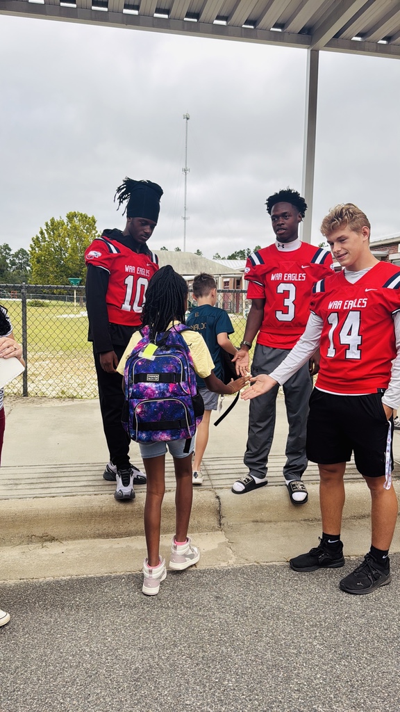 War Eagle Football Players giving hi-fives to students