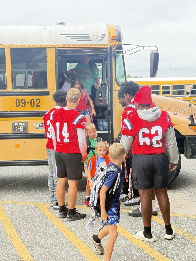Students getting hi -fives getting off the bus!