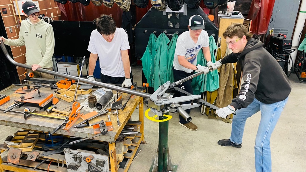 Shop students bending pipe for picnic table project.