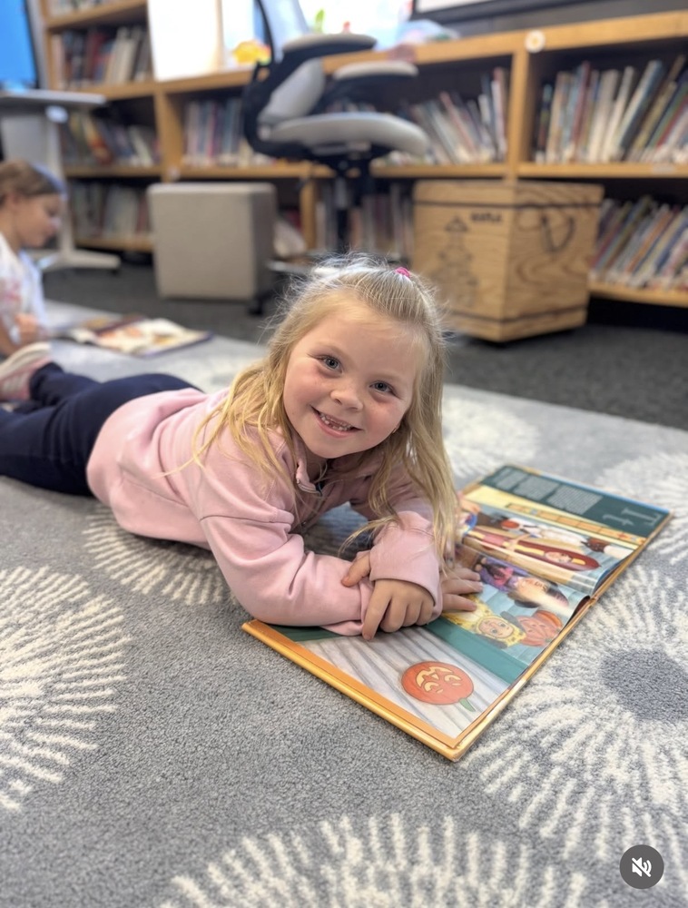 student reading on the rug in STEM class