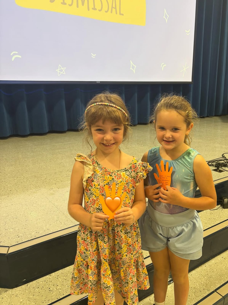 two first graders and their high fives from the assembly