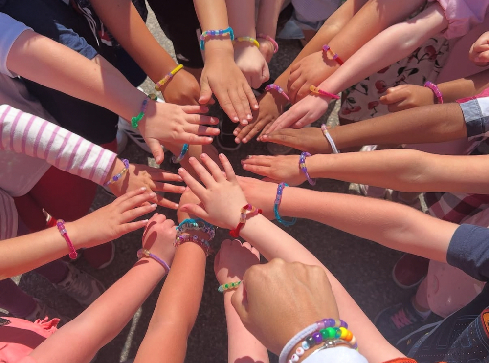 kindergarten hands in a circle with colorful beaded bracelets