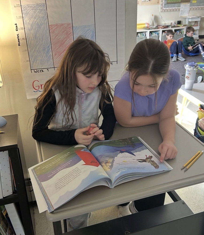 two second graders reading together