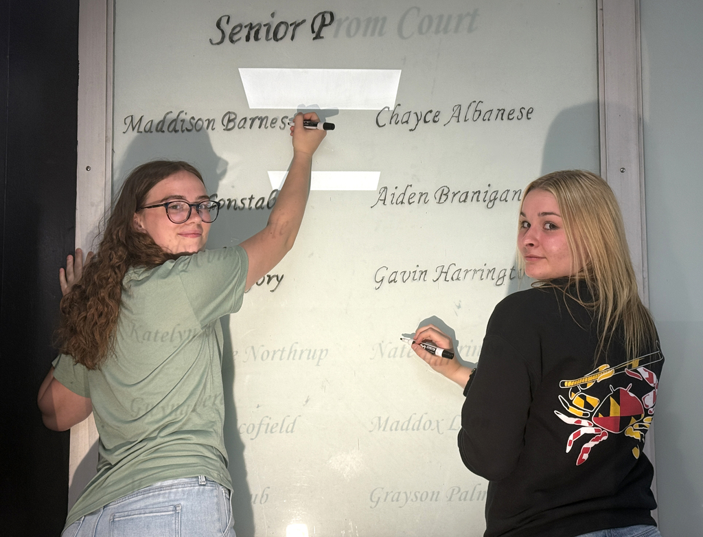 Students working on putting the names on the windows outside the high school office. 