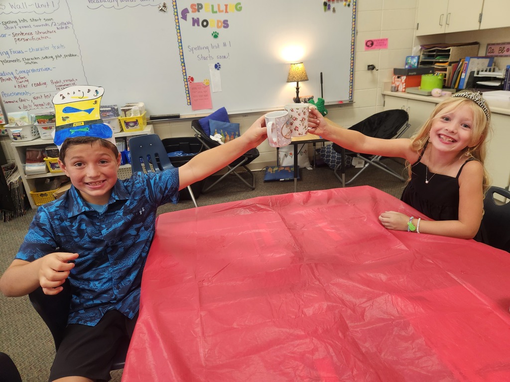 Two students cheersing coffee mugs