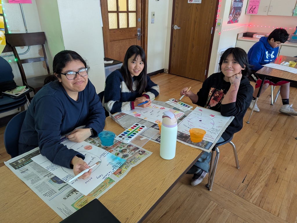 three students painting with watercolors