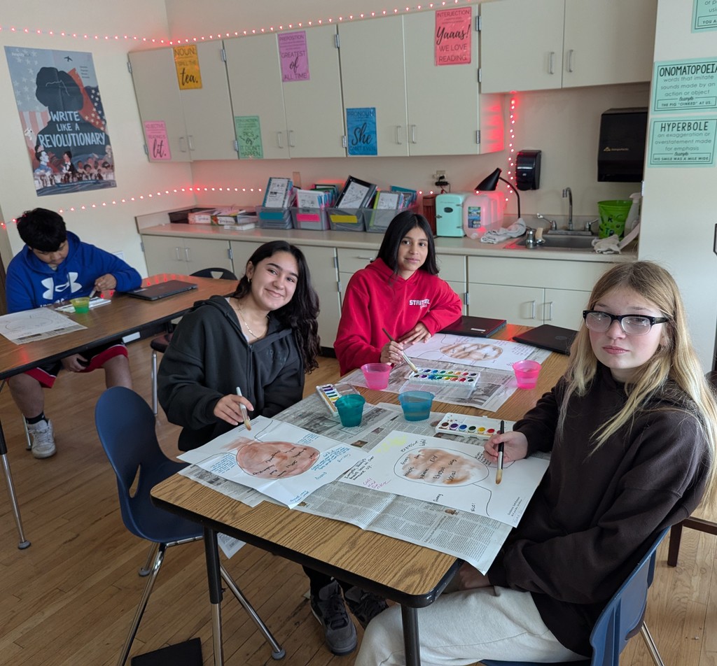 three students painting with watercolors