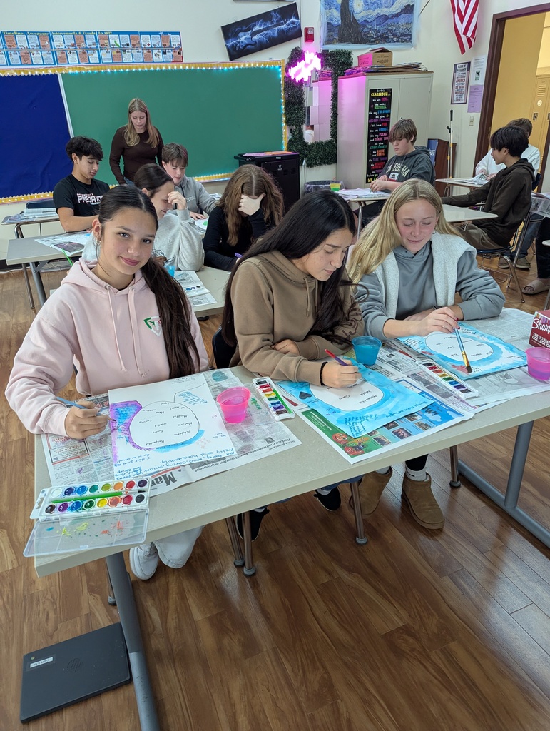 three students painting with watercolors
