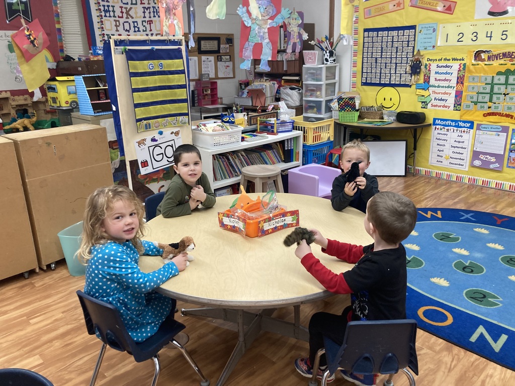 4 students playing with finger puppets. 