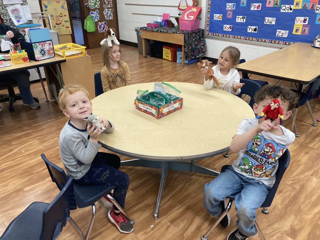 4 students playing with finger puppets. 